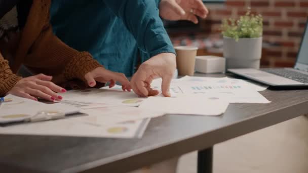 Close up of colleagues analyzing data rate charts on papers — Stock Video