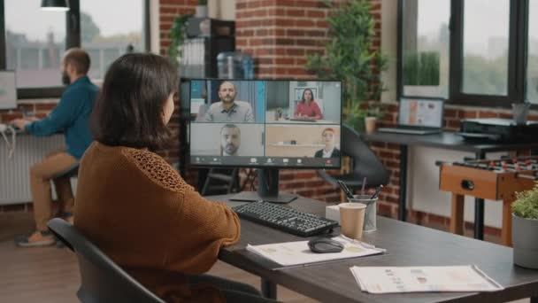 Pracownik korzystający z połączenia wideo na komputerze, aby porozmawiać z kolegami z pracy — Wideo stockowe