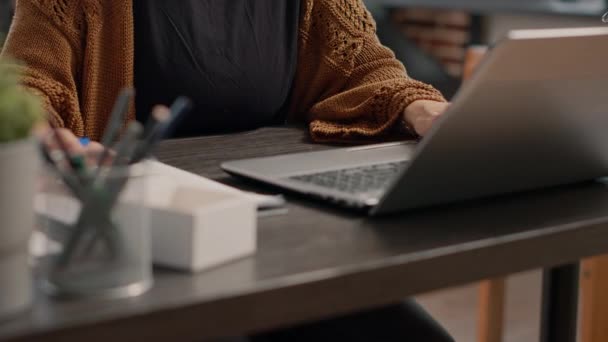 Close-up van werknemer werken met laptop en het nemen van ntotes — Stockvideo