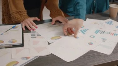Veri oranı grafikleriyle kağıtları kontrol eden meslektaşları kapat