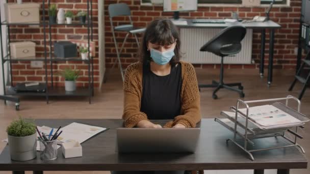 Dizüstü bilgisayar kullanan ve kağıtları oran çizelgeleriyle kontrol eden kadın — Stok video