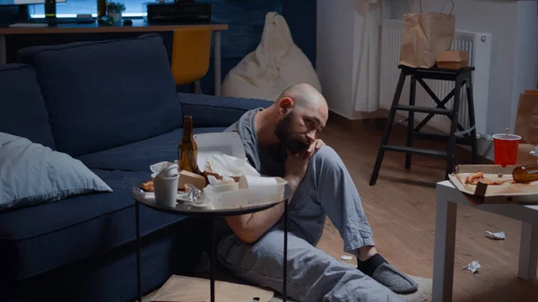 Разочарованный больной человек сидит на полу, чувствуя стресс — стоковое фото