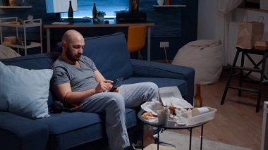 Bunalımlı adam müzik dinliyor, kulaklık takıyor, yalnız oturuyor.