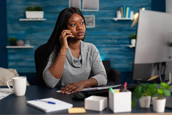 Африканська американка розмовляє по телефону на віддаленій роботі. — стокове фото