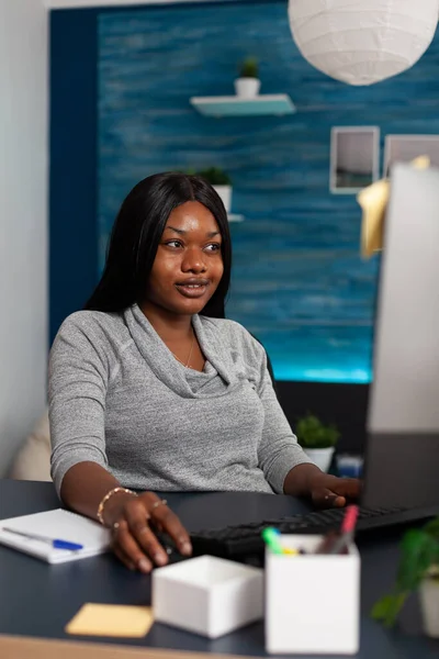 Adulto sorrindo fazendo trabalho remoto com computador e teclado — Fotografia de Stock