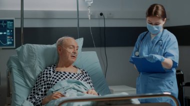 Hastane hemşiresi hasta hastayı kontrol ediyor.