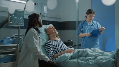 Afro-Amerikalı doktor hastanede hasta bir hastayla konuşuyor.
