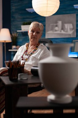 Çizim yapmak için kıdemli sanatçının elinde defter var