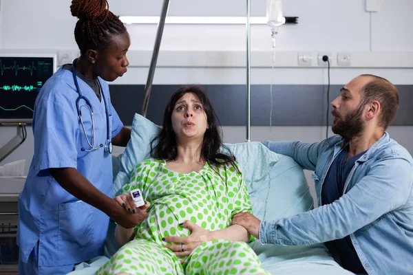 Беременная женщина с болью получает медицинскую помощь — стоковое фото