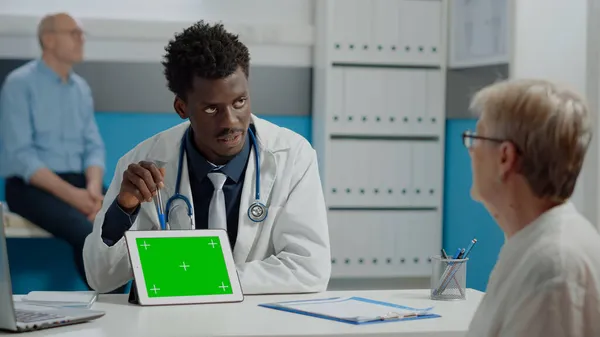 Médecin utilisant une tablette professionnelle avec écran vert horizontal — Photo