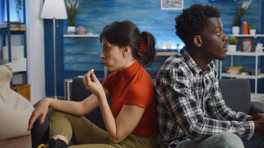 Evlilik sorunları olan ırklar arası bir çift oturma odasında bağırıyor.