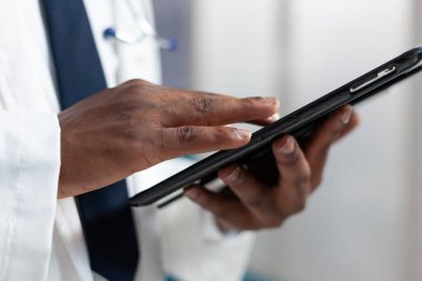Tablet bilgisayar tutan Afrikalı Amerikalı terapistin yakın çekimi.