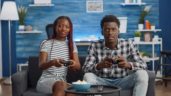 Африканські американці грають у відеоігри з джойстиками. — стокове фото