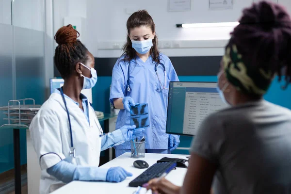 Enfermeira que dá radiografia pulmonar ao radiologista afro-americano — Fotografia de Stock