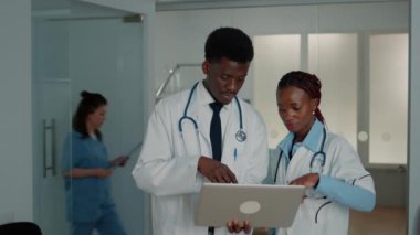 Dizüstü bilgisayarla çalışan Afro-Amerikan doktorlardan oluşan bir ekip.