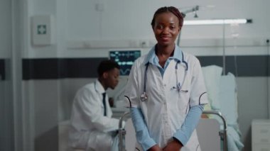 Hastane koğuşunda duran pratisyen hekimin portresi.