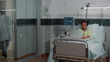 Hastalıklı bir hasta müzik dinlemek için kulaklık kullanıyor.