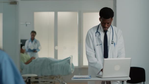 Médecin généraliste regardant ordinateur portable moderne au travail — Video