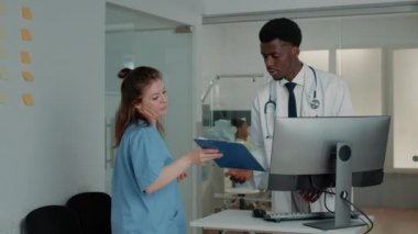 Bilgi edinmek için bilgisayara bakan doktor.