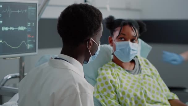 Zbliżenie lekarza rozmawiającego z młodym pacjentem w łóżku — Wideo stockowe