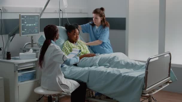 Team of african american doctors consulting patient in bed — Stock Video