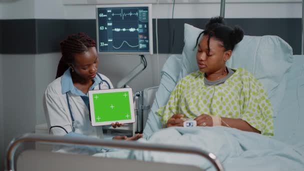 Doktor a pacient při pohledu na horizontální zelenou obrazovku na tabletu — Stock video