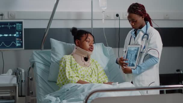 Arzt erklärt Patientin mit Halsband Röntgenbilder — Stockvideo