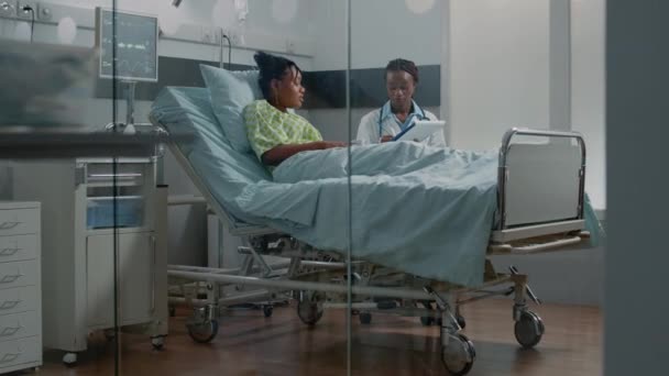 Doctor doing consultation with young patient in hospital ward — Stock Video