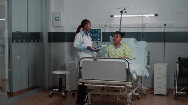 African american doctor doing consultation with patient in bed — Stock Video