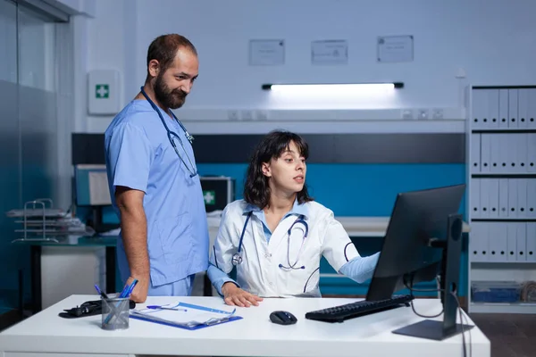 Équipe médicale analysant l'écran de l'ordinateur pour l'information de contrôle — Photo
