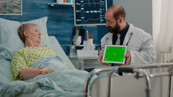 Läkare som håller horisontell grön skärm på digital surfplatta — Stockfoto