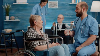 Tıbbi asistan su bardağında coşkulu bir hap hazırlıyor.