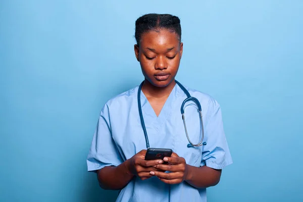 African american practitioner nurse holding smartphone