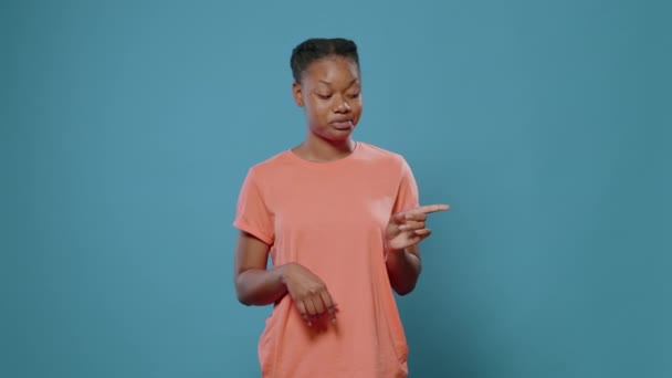 Mujer afroamericana señalando con los dedos hacia los lados en el estudio — Vídeo de stock