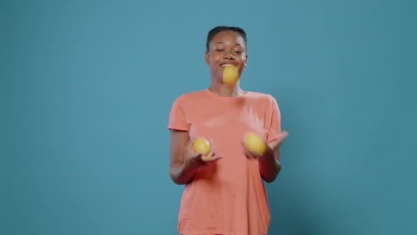 Wanita positif juggling dengan lemon segar dan tersenyum — Stok Video