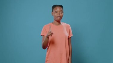 Afro-Amerikalı kadın işaret parmağını kameraya doğrultuyor.