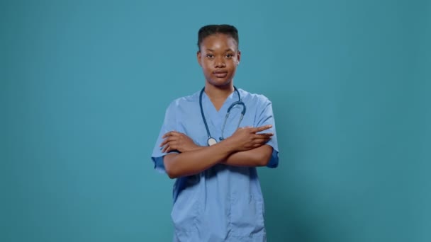 Lékařská asistentka stojící se zkříženýma rukama ve studiu — Stock video