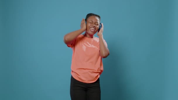 Afrikansk amerikansk kvinna lyssnar på musik för att sjunga — Stockvideo