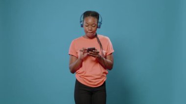 Kulaklıklı genç bir yetişkin dans hareketleri yapıyor.