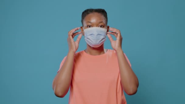 Junge Frau zieht Gesichtsmaske ab und blickt in Kamera — Stockvideo