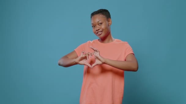 Jeune femme faisant symbole de forme de coeur avec les mains — Video