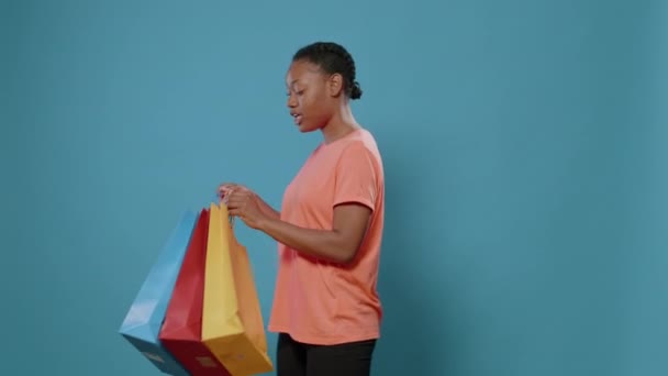 Spannende vrouw presenteert boodschappentassen met kleding — Stockvideo