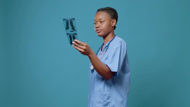 Портрет медсестри жінки, яка дивиться на результати сканування рентгенівських променів — стокове відео