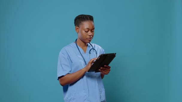 Enfermeira afro-americana de uniforme usando tablet digital — Vídeo de Stock