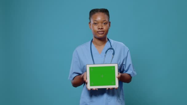 Assistente médico mostrando tablet com tela verde horizontal — Vídeo de Stock