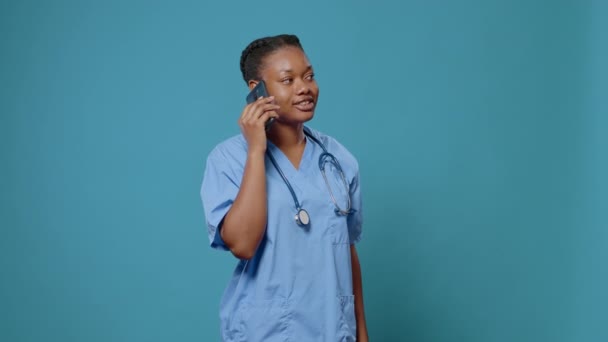 Portret pielęgniarki w mundurze rozmawiającej przez telefon — Wideo stockowe