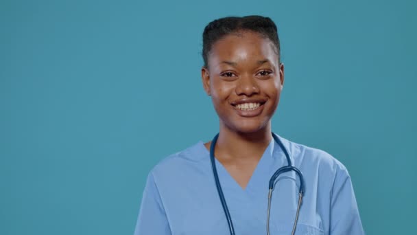 Primer plano de la enfermera afroamericana sonriendo a la cámara — Vídeos de Stock