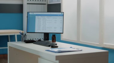 Masanın üzerinde hasta bilgileri olan bilgisayar ekranını kapat