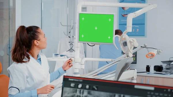 Kobieta analizuje zielony ekran na monitorze i zęby rentgen — Zdjęcie stockowe