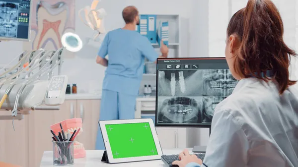 Orthodontist using horizontal green screen on tablet